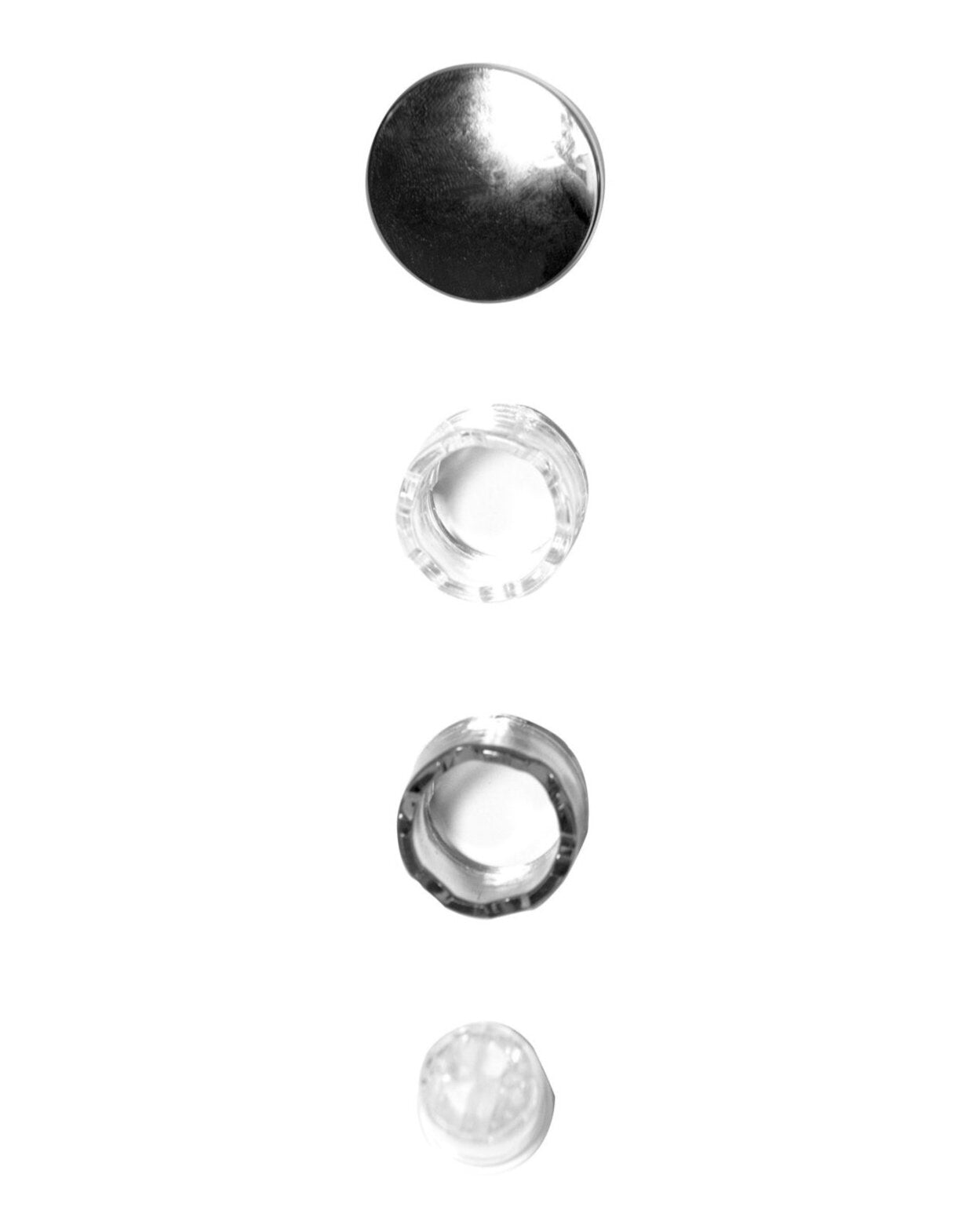Four different circular objects arranged vertically, including a metallic one at the top and various transparent ones below.