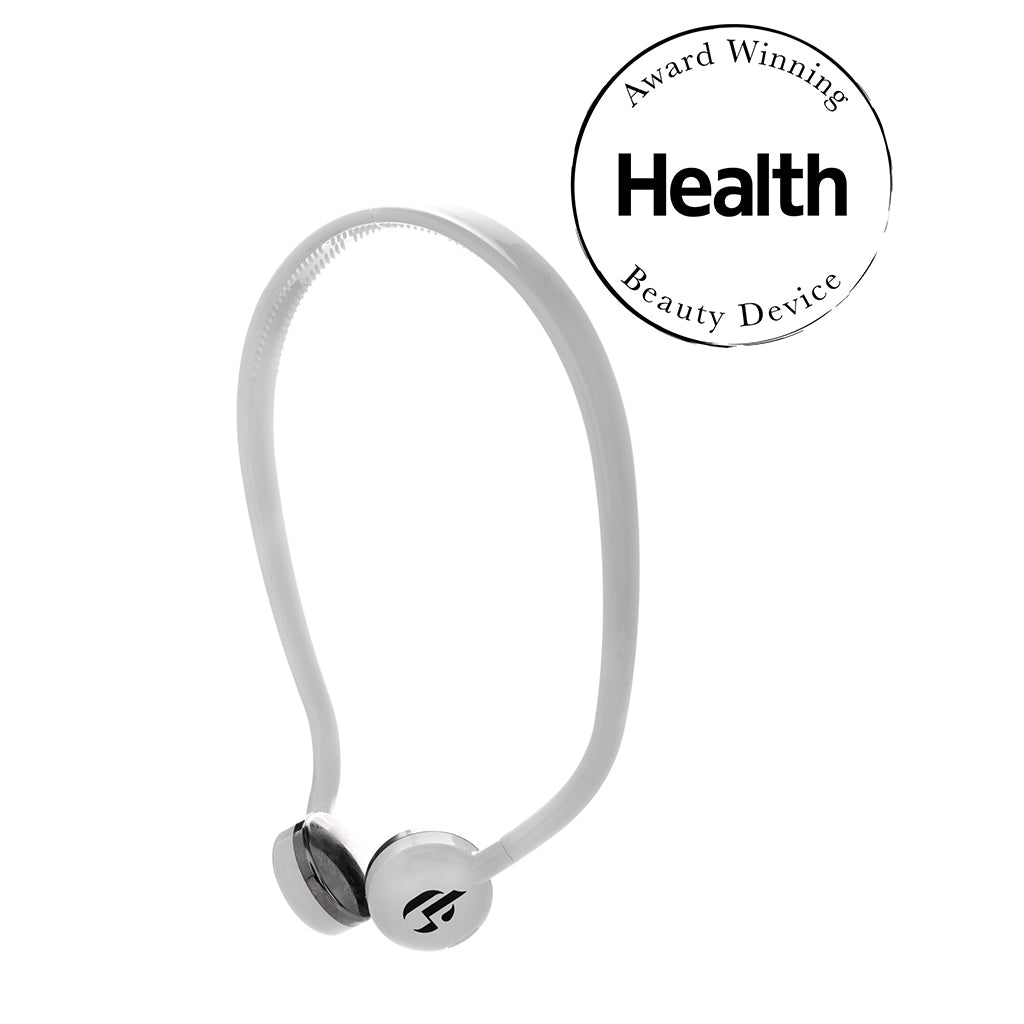 A stylish white headband with two circular speakers, labeled as an award-winning beauty device.