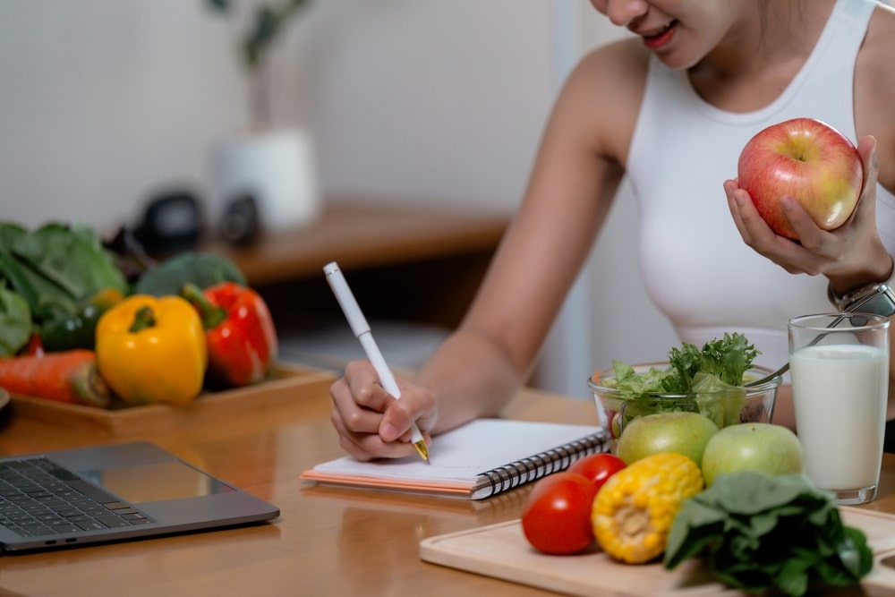 Nutritionist,Writing,Notes,On,A,Diet,Plan,Using,A,Laptop